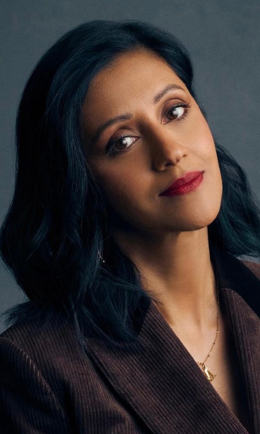 Manjinder Virk A headshot of Manjinder Virk, a young British writer/director/actor with Indian heritage. She las long black hair and looks to the viewer with her head tilted to the left. She is wearing a brown jacket and a small silver necklace.